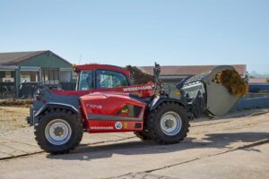 Weidemann T7042 telehandler transporting silage with front bucket attachment on farmyard — heavy-duty agricultural material handler