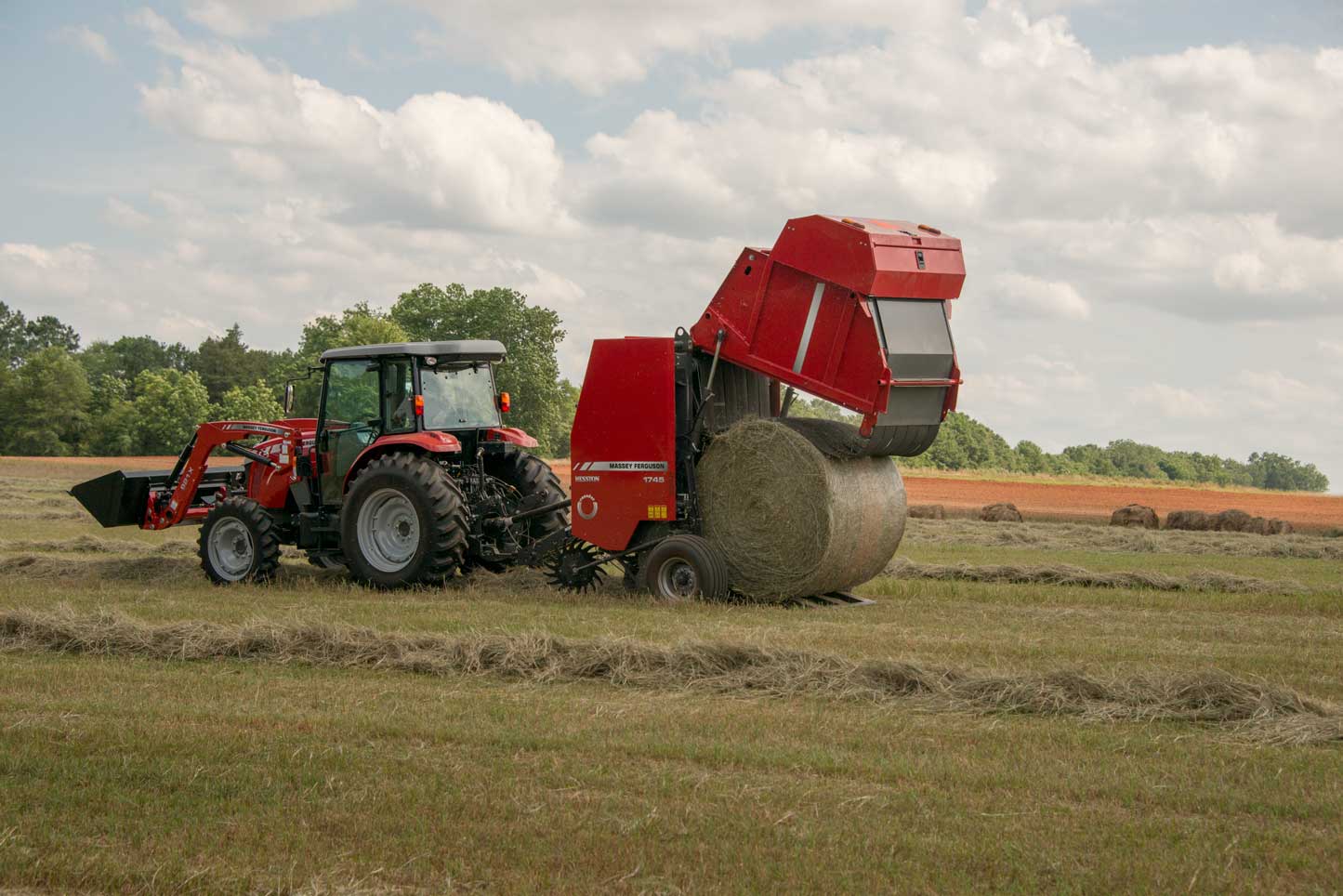 Massey Ferguson 1745D round baler dumping bale in field