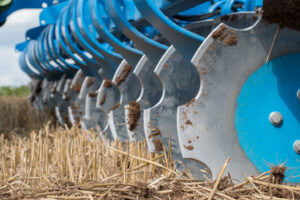 Close-up view of Lemken Heliodor 9 compact disc harrow blades working in a stubble field, showcasing sharp serrated steel discs for efficient soil cultivation and seedbed preparation.