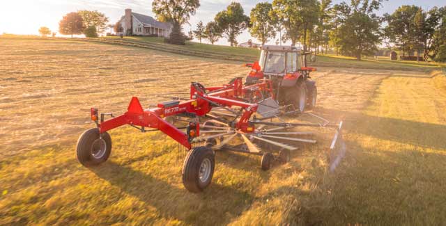 Massey Ferguson RK772 rotary rake pulled by tractor forming clean windrows at sunset, showcased by Hanlon Ag Centre, southern Alberta dealer for hay rakes, tractors, and farm equipment.