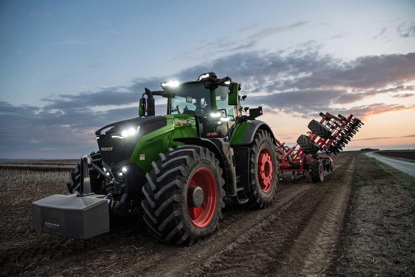 Fendt high-horsepower tractor with LED lighting pulling a tillage implement in a southern Alberta field at dusk, available from Hanlon Ag Centre for prairie farming operations.