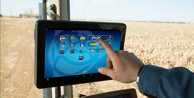 Farmer using Trimble RTX correction on in-cab display for precision GPS guidance and field accuracy in southern Alberta