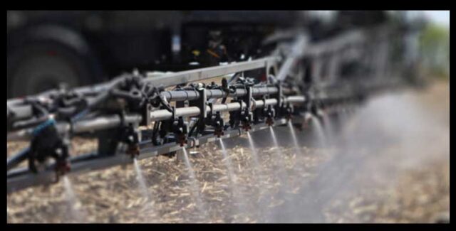 AGCO application spray parts displayed on a sprayer boom applying liquid application product to a field. Order spray parts at Hanlon Ag Centre in Lethbridge, Alberta.