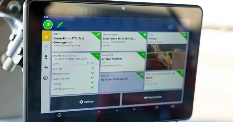 Close-up of a Trimble GFX-1260 in-cab display in a tractor showing CenterPoint RTX guidance active, with a John Deere 8R 245R vehicle profile and Brillion mulcher implement settings